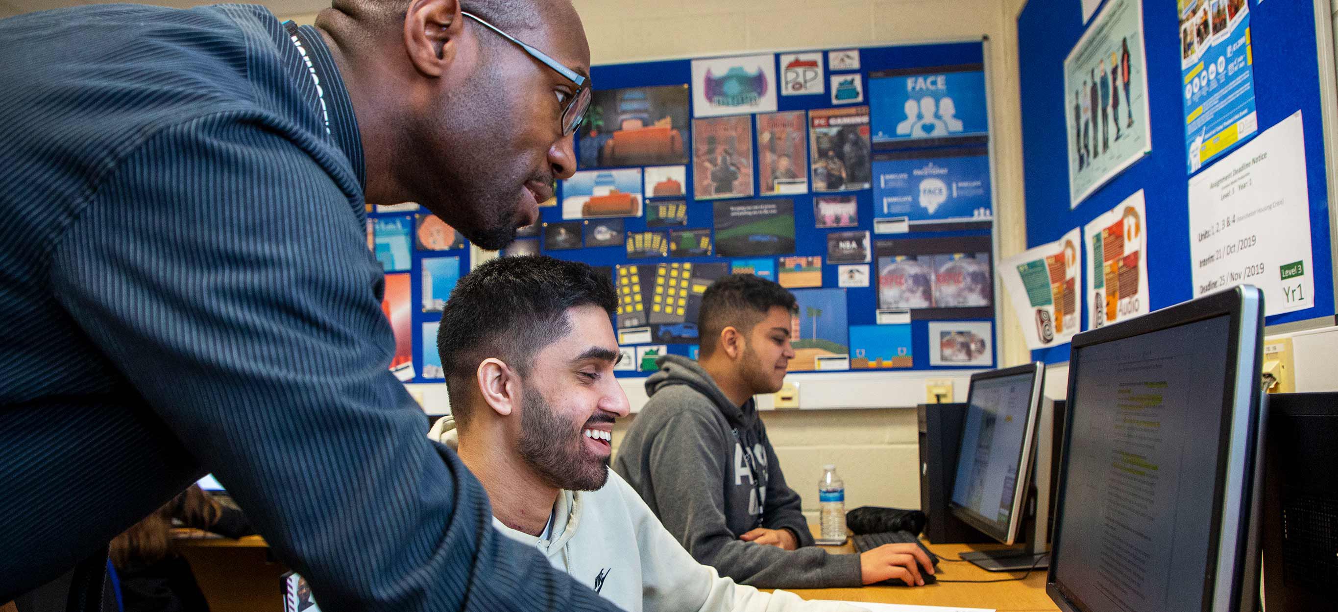 A tutor helping a student on a computer